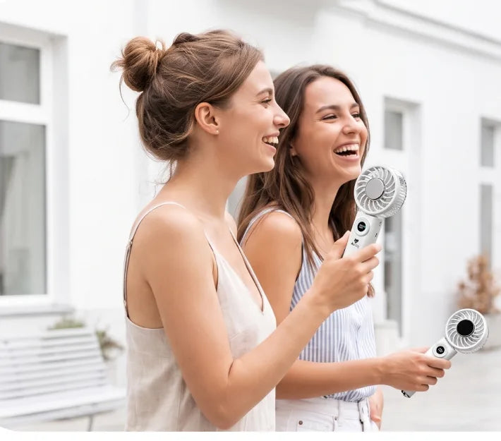 Two friends staying cool with Airdog F200 handheld fans while out walking