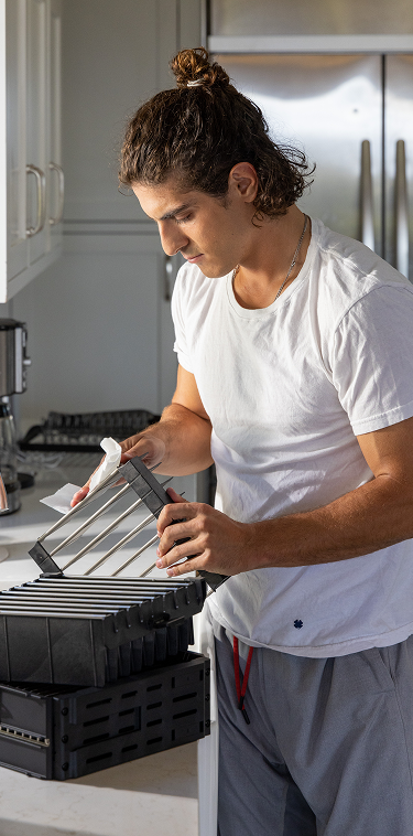 Hands cleaning AirSoap filter parts at a kitchen sink