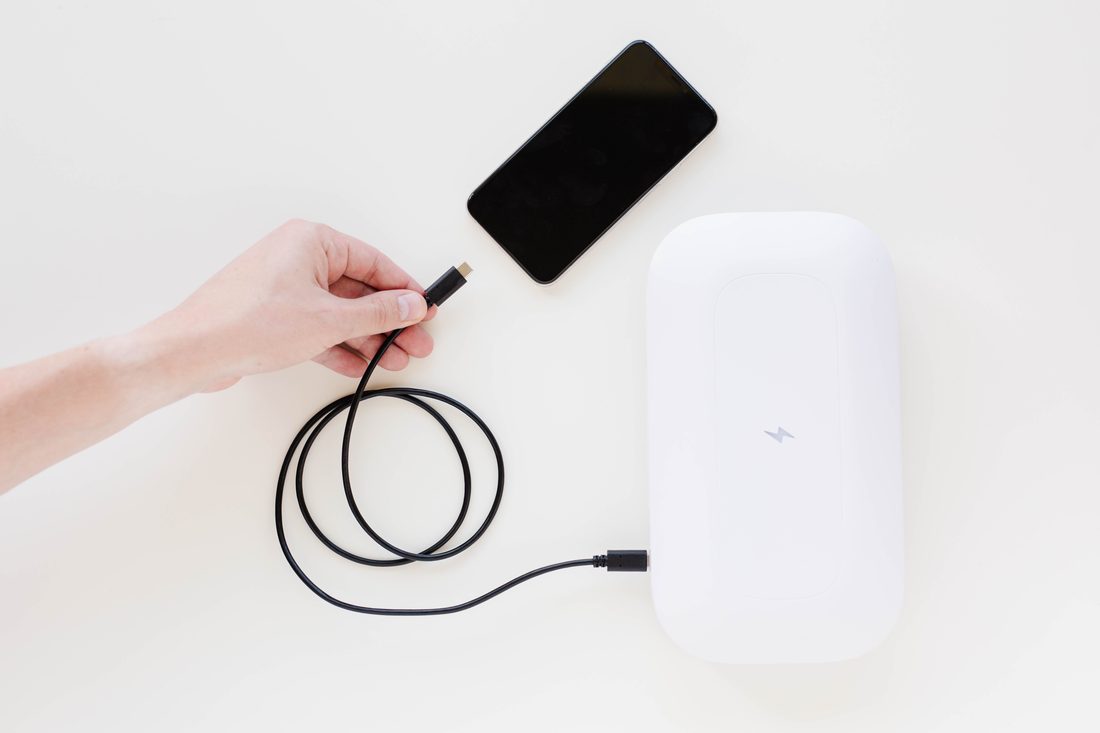 PhoneSoap charging a phone with a GermGuard antimicrobial cable
