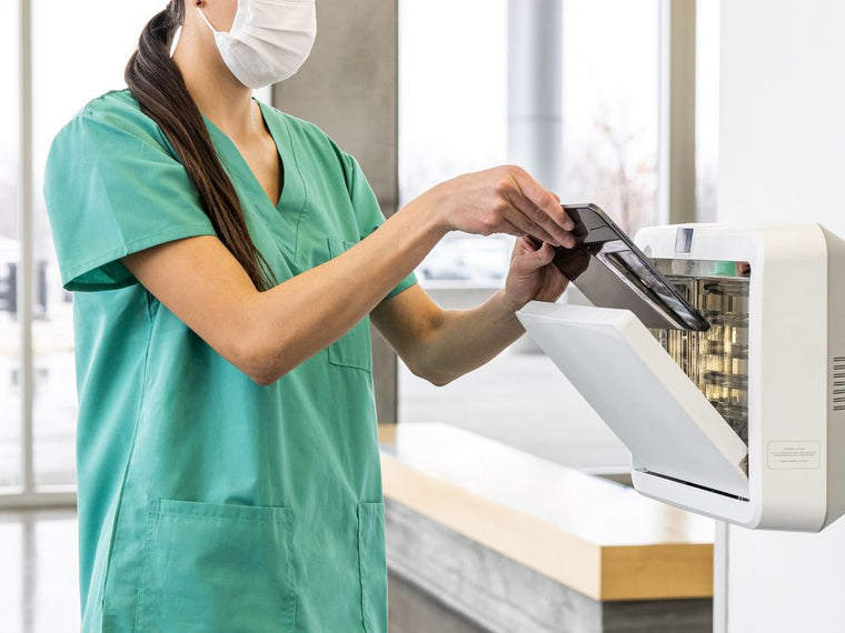 ExpressPro UV-C disinfection station in use in a clinical setting, disinfecting a shared phone between patient encounters