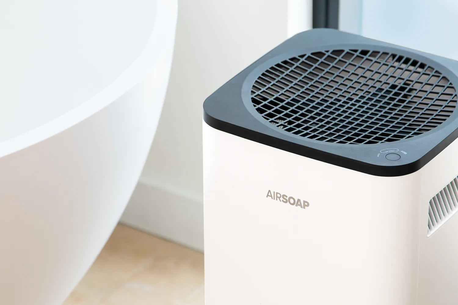 AirSoap air purifier for mold beside a bathtub in a moisture-prone bathroom