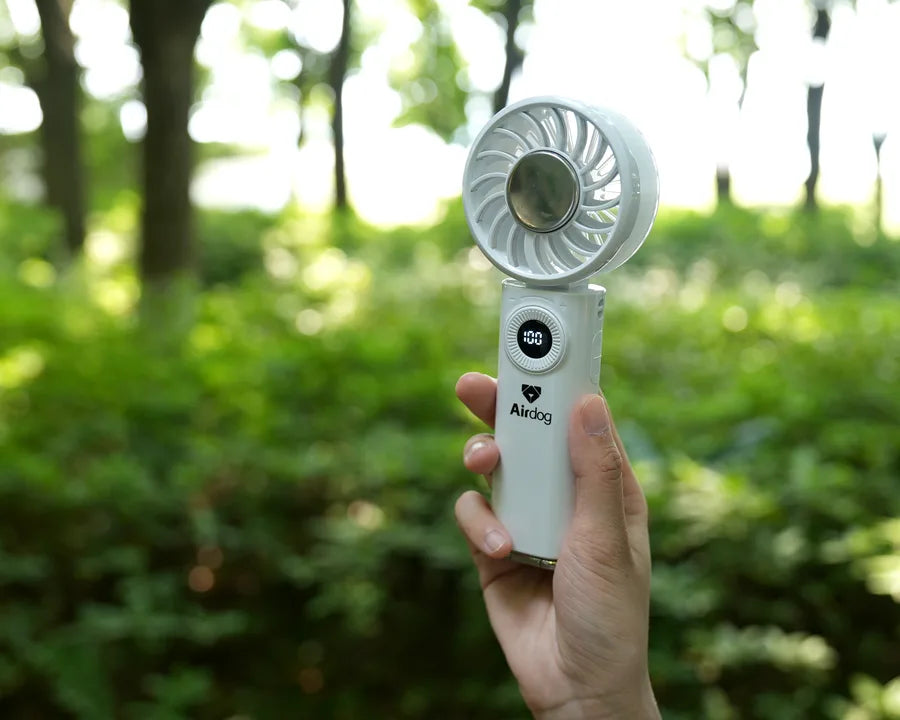 Holding the Airdog F200 cooling fan outdoors in a park